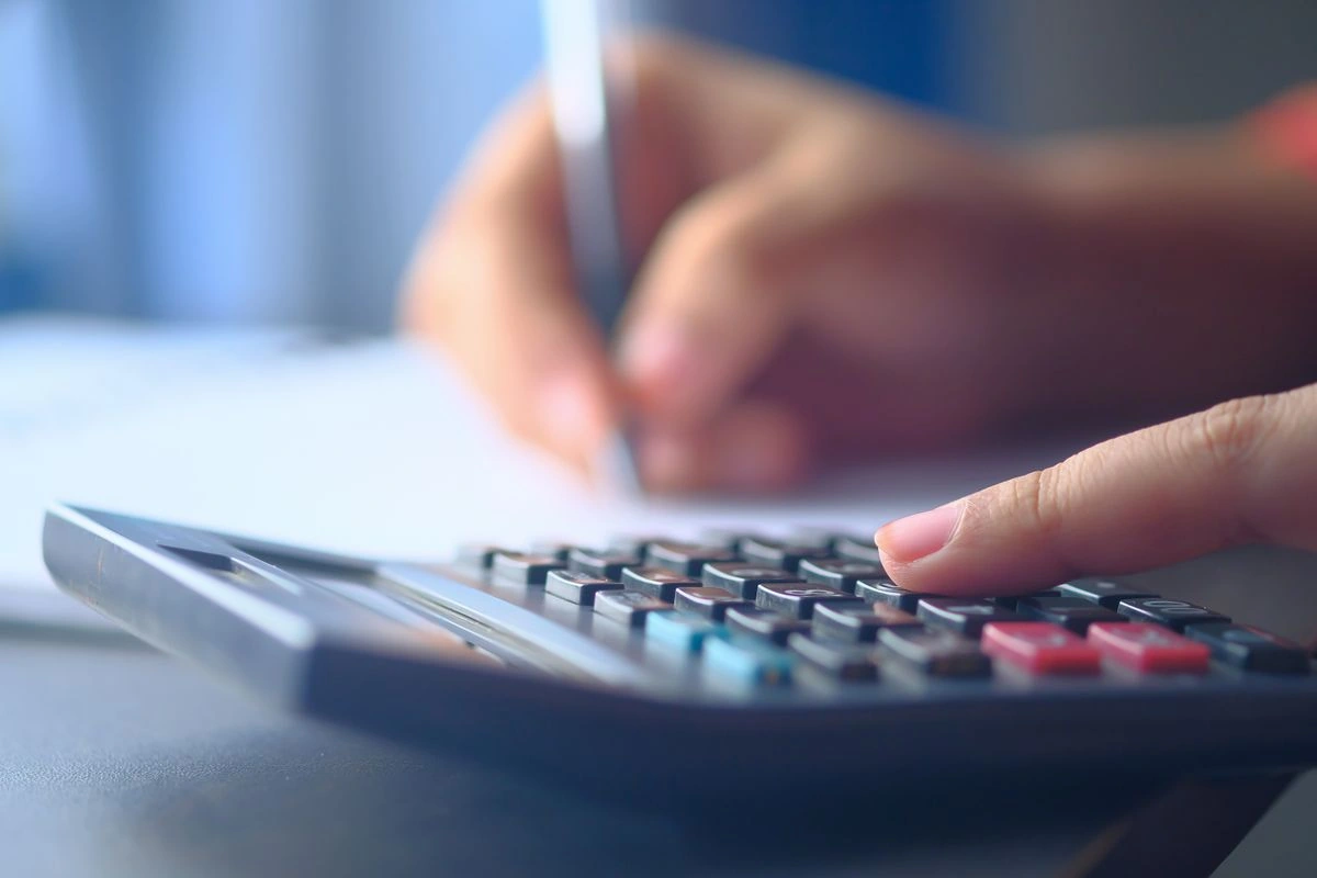 Person using a calculator to estimate a MEPCO electricity bill